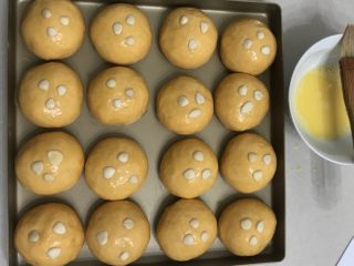 南瓜黄豆粉小餐包,11送进发酵箱，温度调节在34度，湿度保持在％80，发酵一倍大。
12表刷上全蛋液，放上杏仁片装饰。