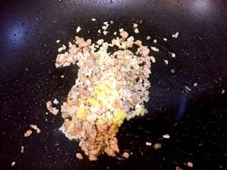 麻婆豆腐,肉糜炒至颜色开始变白，放入姜末和蒜末，翻炒出香味