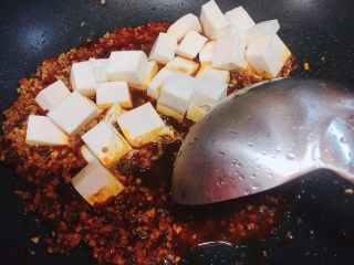 麻婆豆腐,用炒勺光滑的一面沿着锅边推散豆腐，这样豆腐不容易碎