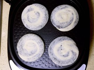发面黑芝麻糖饼,电饼铛预热好，不用抹油，直接放入醒好的芝麻糖饼胚。