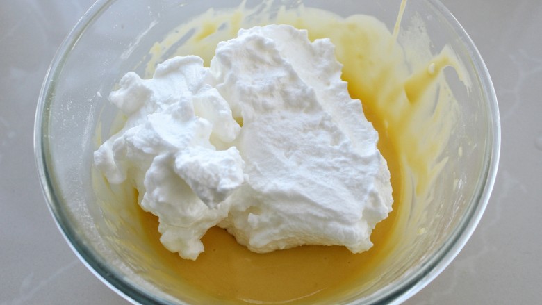 抹茶树桩蛋糕卷,取三分之一的蛋白霜放入蛋黄糊中上下翻拌均匀