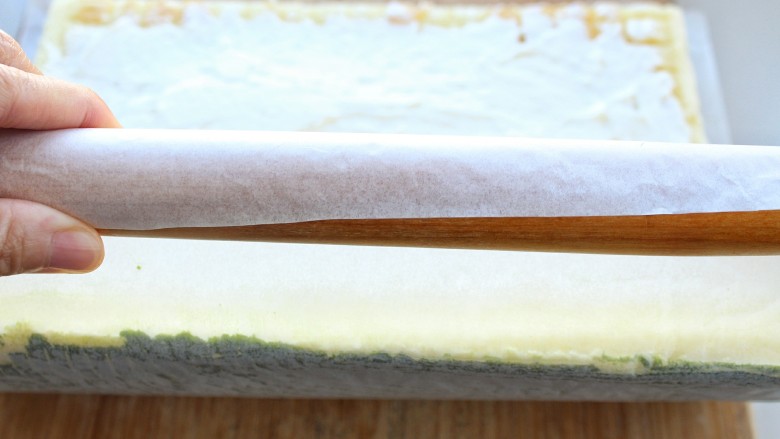 抹茶树桩蛋糕卷,用擀面杖反卷油纸卷起蛋糕卷，包好后放进冰箱冷藏一个小时以上，取出切块食用即可
