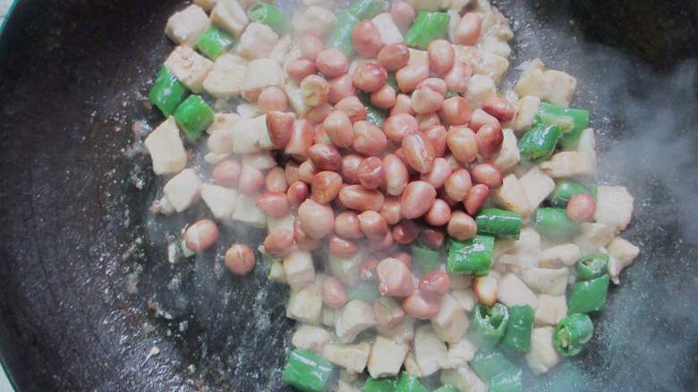 青椒鸡丁,放入花生翻炒1分钟，放入盐炒匀即可出锅。