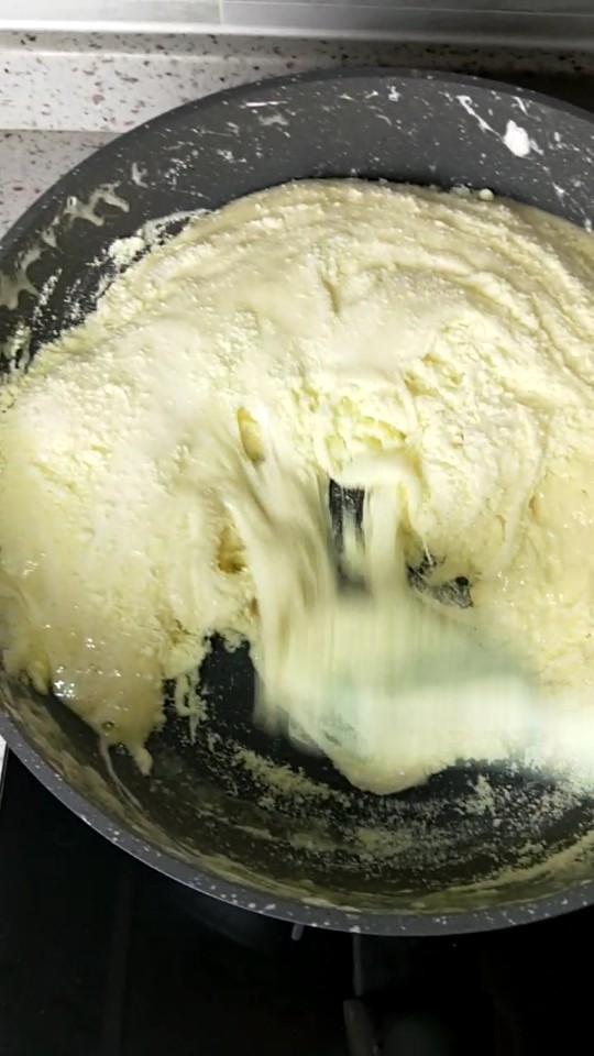 Q软牛杂糖,接着倒入所有的奶粉，30秒后马上离火，利用刮刀混合均匀。