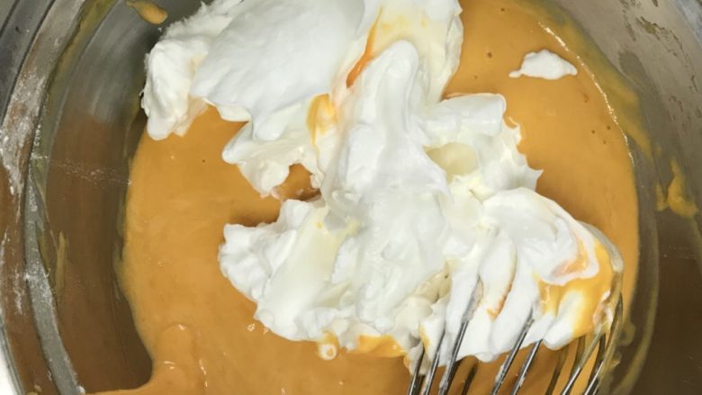 八寸南瓜戚风蛋糕,取三份之一蛋白糊加入蛋黄糊中。