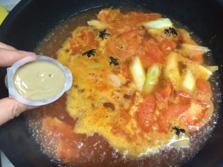 快手暖胃番茄火锅,放入两块浓汤宝，拌匀，把八角夹出来，汤底就做好了。