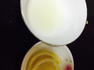 泰式酸辣柠檬清蒸鲈鱼(自创）,半个柠檬把汁挤在碗里，另外半个切成薄片做装饰用。