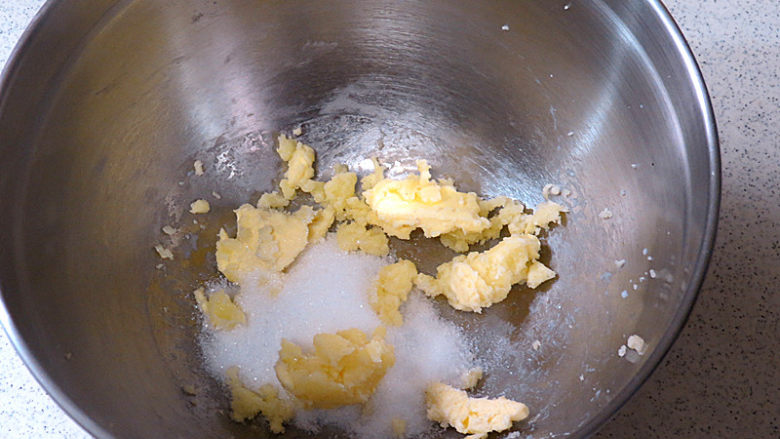 酥脆果香滴法式苹果派,首先制做派皮。黄油自然软化后先用打蛋器打散再加入细砂糖一起打发至颜色变浅