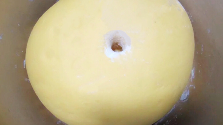 金黄金黄的南瓜馒头,盖上保鲜膜，开始放温暖的地方发酵（我是放烤箱发酵）大概2-3倍大，用手指蘸少量粉，在面团戳小洞，洞口不回缩、不塌陷即可。