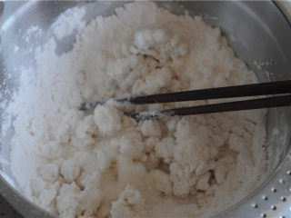 手工花式年糕,将年糕粉倒入大容器里，倒入水，用筷子搅成粗颗粒状