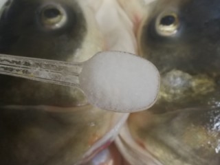 双味鱼头,取适量的盐撒在鱼头上，用手轻轻按摩一下