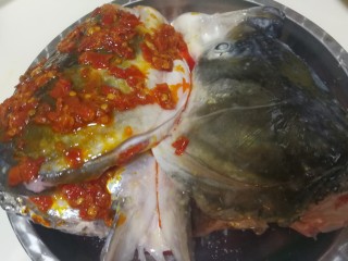 双味鱼头,鱼头的一半浇上适量的红剁椒，如果家里人不吃辣，另外一半可以不用处理