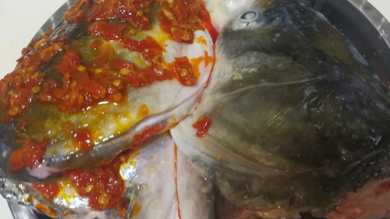 双味鱼头,鱼头的一半浇上适量的红剁椒，如果家里人不吃辣，另外一半可以不用处理