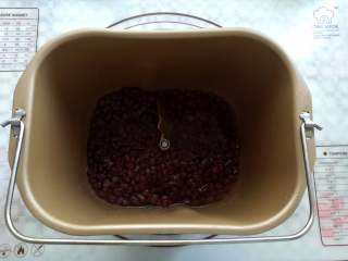 糖渍蜜红豆,取一部分红豆加入少量的水放入面包桶里