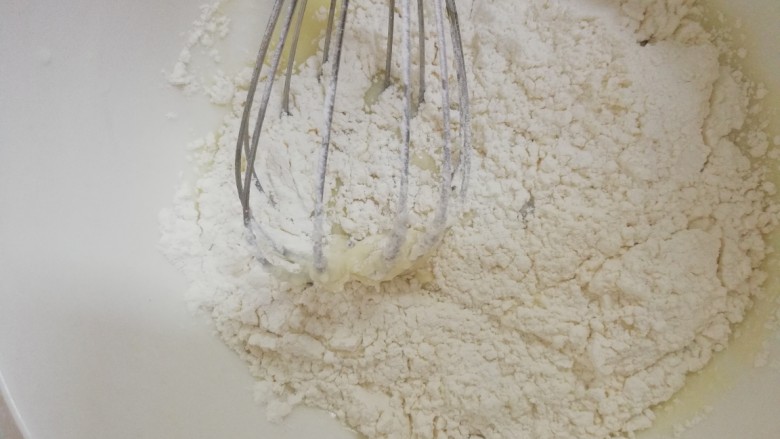 新手也能做的——柔软戚风蛋糕（8寸）,把过筛好的低粉倒入到牛奶混合液里，用z字手法拌匀。拌到没有看到白色颗粒就好。