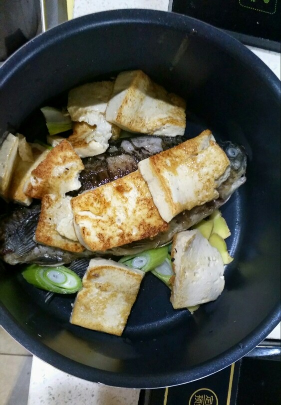 鲫鱼浓汤,豆腐盛出放入汤锅里，把葱姜也一起放进去。