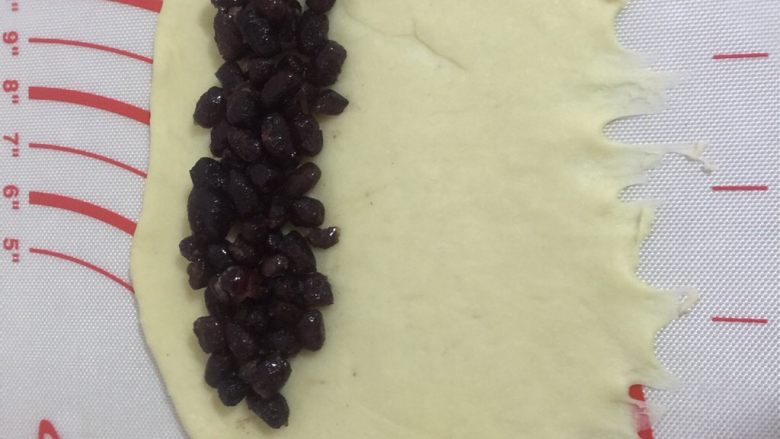 香软芝麻蜜豆包,擀成图上的形状，放蜜豆那边厚点，底部擀薄方便收口