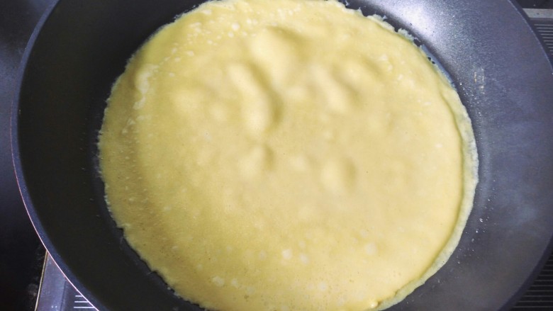 牛奶鸡蛋玉米饼,将面糊用勺舀入锅中，转动锅，成为一个圆饼，全程用最小火。