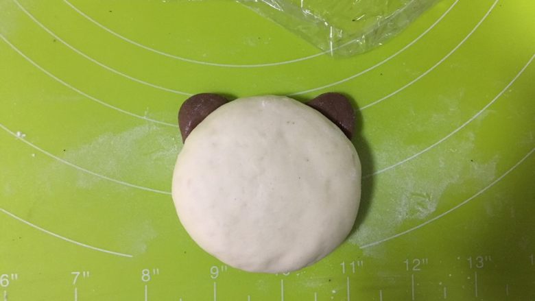 呆萌熊猫豆沙包,耳朵和脸的粘合处沾一点点水，便于粘合