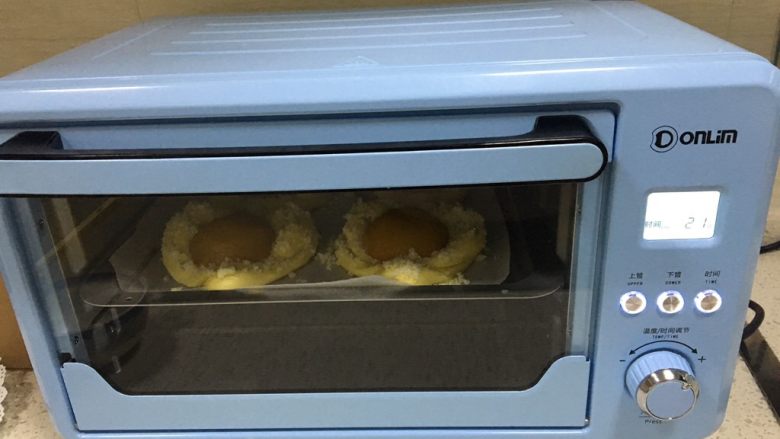 黄桃椰蓉心形面包,烤箱提前预热，上下管调到170度，烤25分钟，中途需要观察面包上色情况，当上色满意以后加盖锡纸