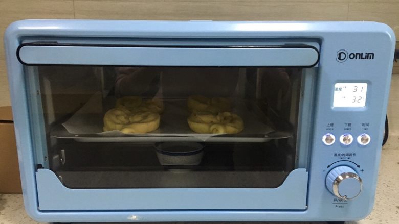 黄桃椰蓉心形面包,烤箱底部放一小碗清水，烤箱调到上下管33度，放入整形好的面团进行第二次发酵，大约30分钟