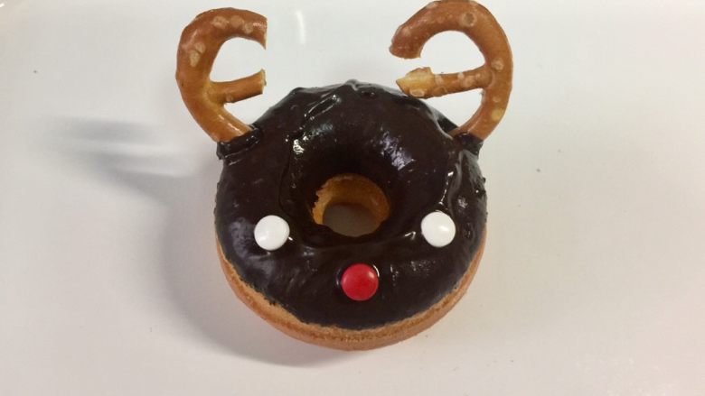 甜美可爱的圣诞甜甜圈,然后把劳伦兹饼干圈掰成两半，做麋鹿的角。饼干圈不太好掰，也可以用整个做鹿角。