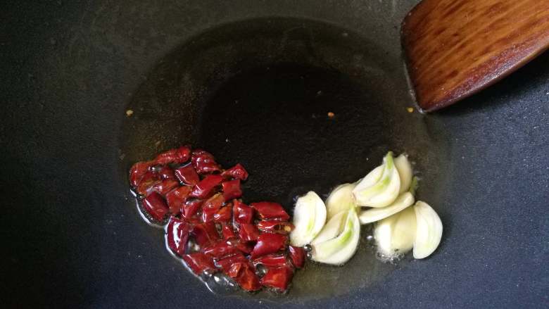 雪菜肉片炒口蘑-米饭杀手,先放入干辣椒翻炒，再放入蒜头片。