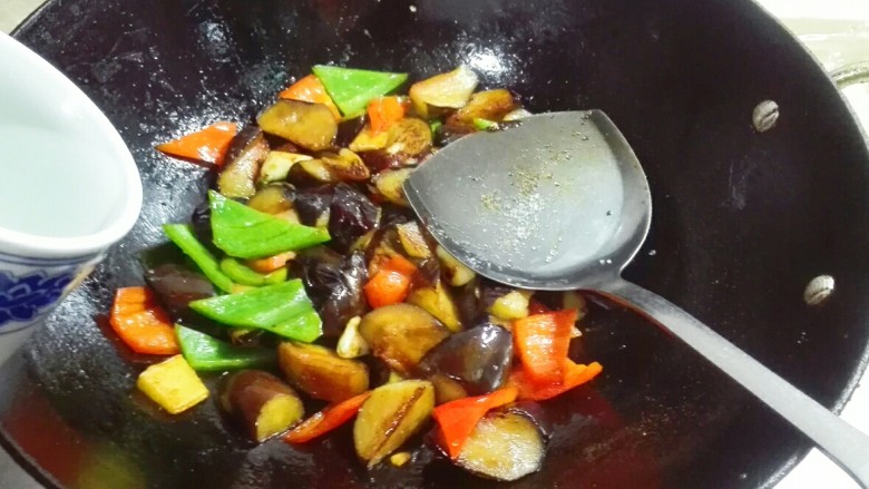万紫千红总是春~青红双椒滚刀紫茄子,放适量热水盖上锅盖中火烧焖三分钟
