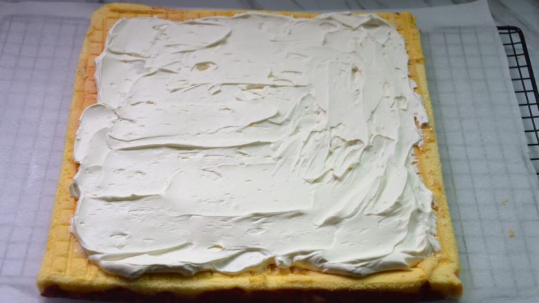 红丝绒树桩蛋糕卷,蛋糕条纹面放在下面，抹上奶油