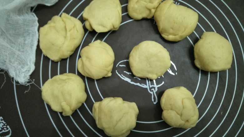 咖喱薯仔餐包,将面团放入案板上揉一会进行排气后分成十份揉圆盖布醒发十分钟。