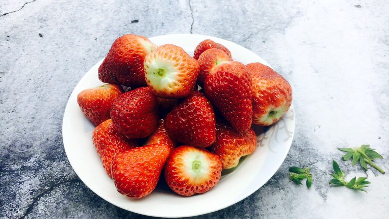古法熬制 草莓酱,把所有摘好的草莓放在盘子里。