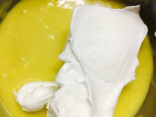 香橙蛋糕卷,打好的蛋白，取一部分加入蛋黄糊中。搅拌均匀。不要画圈。翻拌
