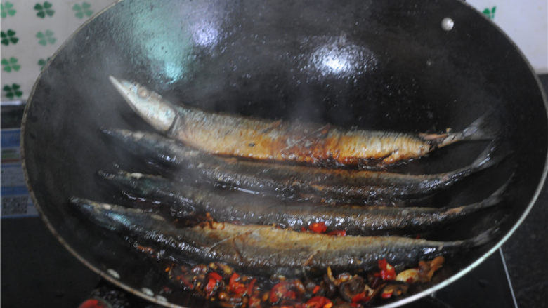 干锅秋刀鱼,将煎好的秋刀鱼摆放进锅里
