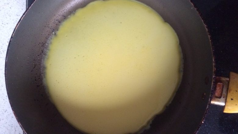 香蕉班戟,平底锅加热，离火加入一勺蛋液