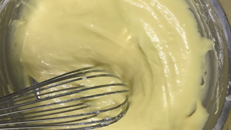 柠檬香戚风纸杯蛋糕,蛋黄直接放进面糊盆里，用手动打蛋器搅拌均匀，不要过度搅拌防起筋，放一边备用。