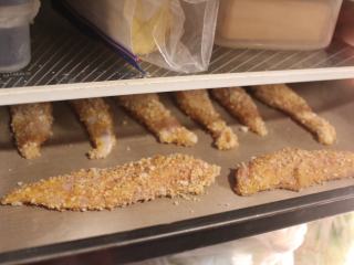 泰式吮指鸡块,将沾好粉的鸡肉摆放在烤盘上，放入雪柜冷藏20分钟。这样可以使沾裹的米果粉黏住鸡块，不会轻易掉落。