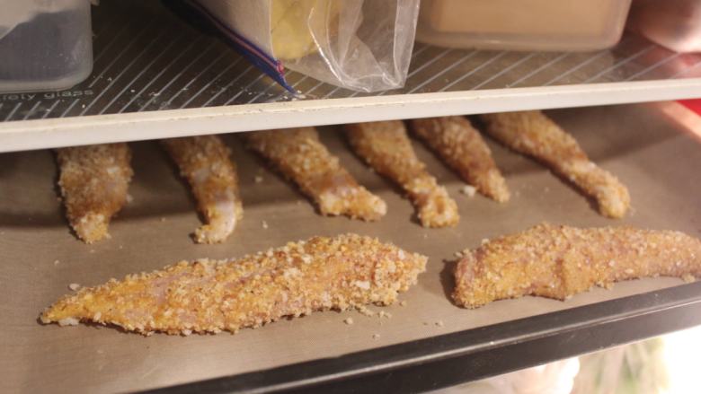 泰式吮指鸡块,将沾好粉的鸡肉摆放在烤盘上，放入雪柜冷藏20分钟。这样可以使沾裹的米果粉黏住鸡块，不会轻易掉落。