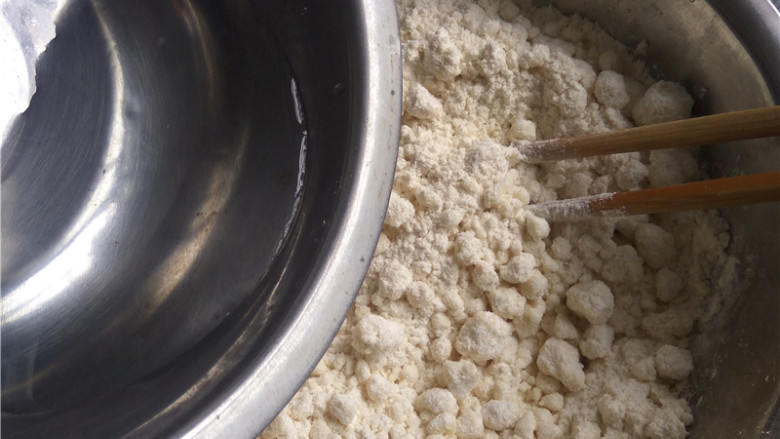 玉米煎饼,徐徐倒入适量清水；一边倒入清水，一边用筷子划圈搅拌；