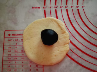 黑芝麻面包圈,取一个面团擀圆，中间包入适量黑芝麻馅，