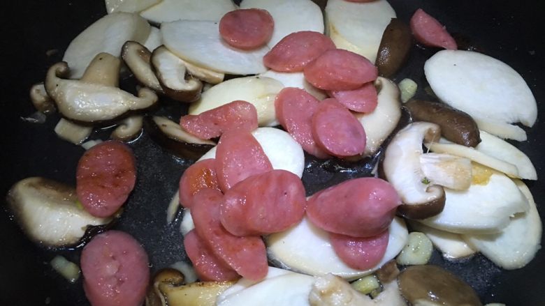 双菇炒热狗,倒入没有完全变熟的热狗，盖上锅盖煮一会