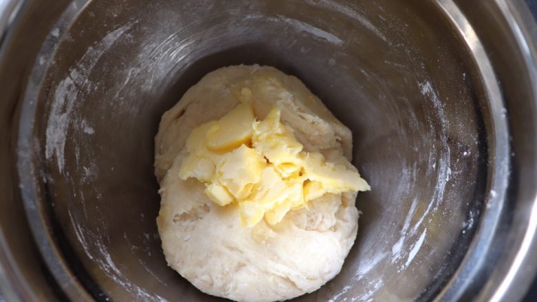 红豆沙面包圈,倒入提前室温软化好的黄油，用手揉匀，大概十分钟。