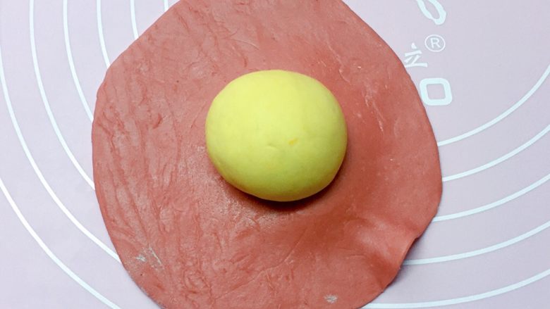 福袋馒头,取一黄色小面团搓成圆球，放在红色面皮中间。
