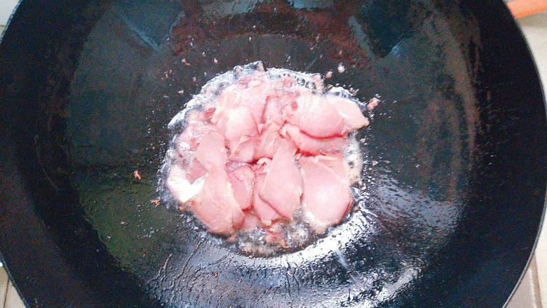 双椒茭头炒腊肉,腊肉片倒入热油锅里煸炒出香味！