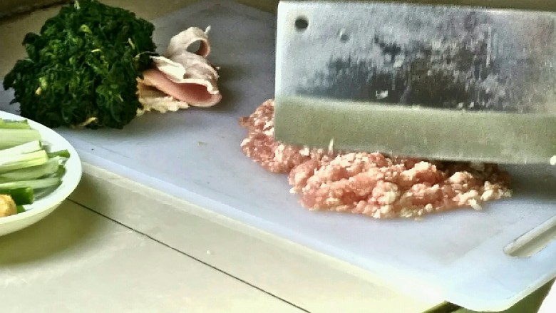 手工荠菜肉馅饺子,剁馅，因为肉皮不好剁，所以可以将肉皮切下来。