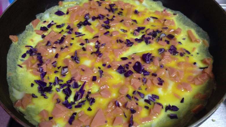 花生酱三明治,不沾锅下少许油，倒入火腿蛋液摊开，蛋液凝固以前撒入少许紫橄榄碎煎熟