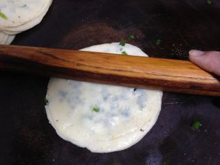酥脆的饺子皮版葱花饼,
用手捏把饺子皮的边缘，以防油和葱会漏出。然后用擀面杖从中间向外面按压