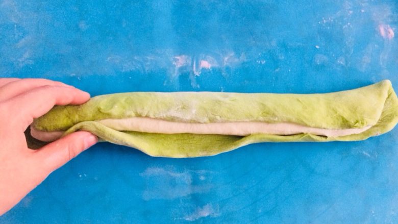 翡翠碧玉饺子,将绿色面片包裹上白色长条，再搓成一个长条。