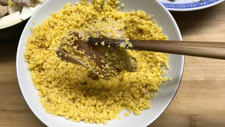 #厨房挑战#  荤菜  小米粉蒸肉,把腌制好的肉拿出在沥干水的小米中滚一下让肉片都沾上小米。