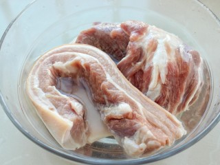 东北酸菜猪肉炖粉条,将五花肉和大骨头放入清水中浸泡一个小时，中途换两次水，然后清洗干净