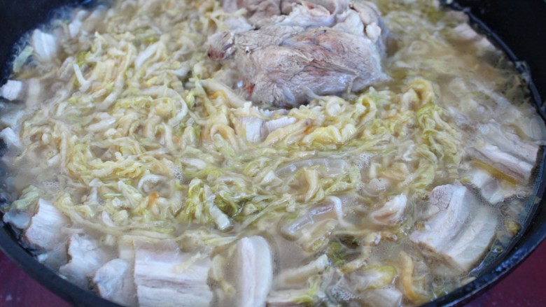 东北酸菜猪肉炖粉条,再倒入炖大骨头的肉汤煮开，改小火炖半个小时